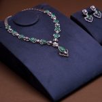 Elegant emerald necklace and earrings set on velvet background, perfect for showcasing luxury and style.